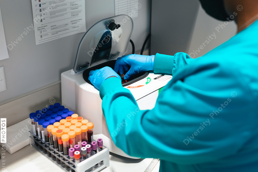 Black healthcare professional uses centrifuge machine in laboratory at medical facility