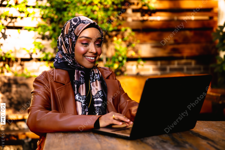 Professional Muslim businesswoman working remote at local coffee shop