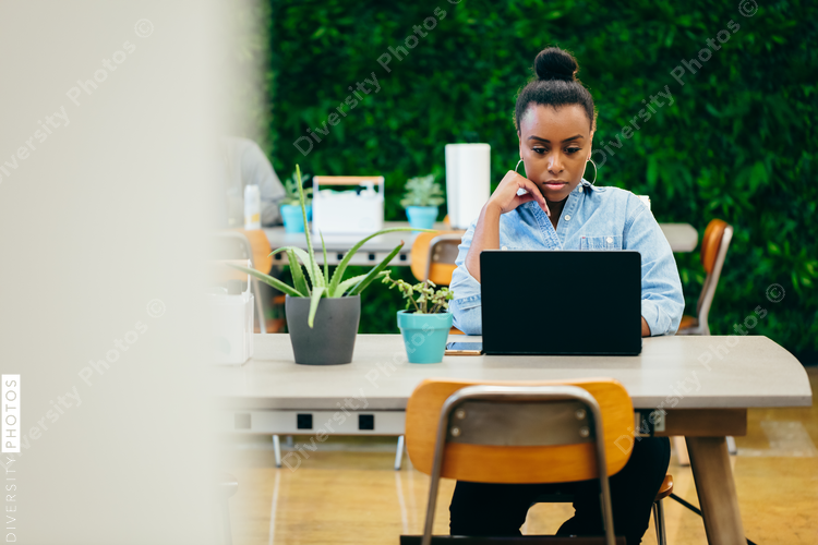 Woman consultant works in co-working business space socially distanced