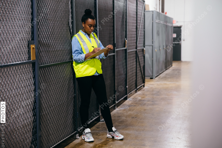 African American woman in datacenter surveying warehouse is secure