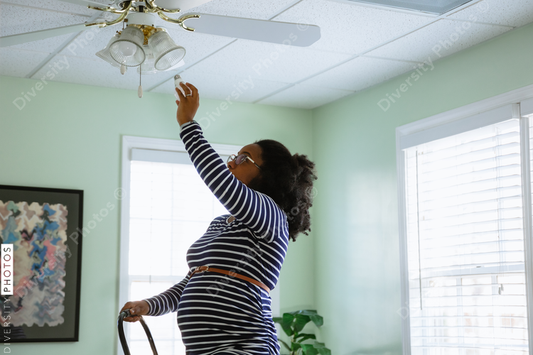 Black pregnant woman installs energy efficiency LED light bulbs at home residence DIY