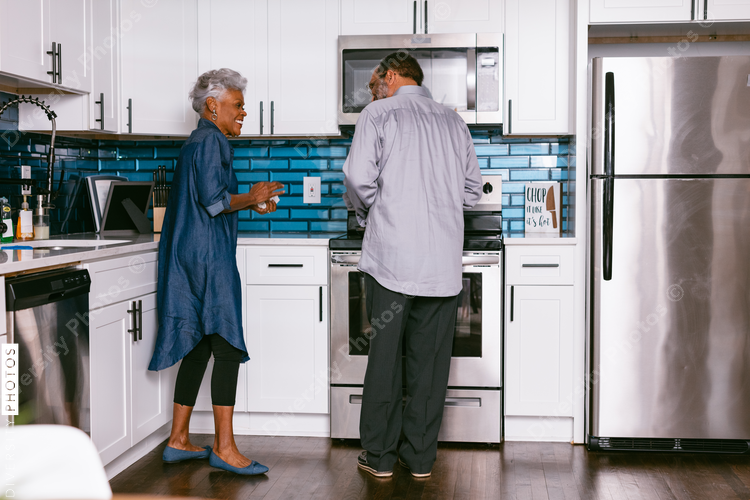 Senior couple at home in kitchen enjoying retirement