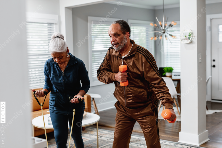 African American senior couple exercises together at home