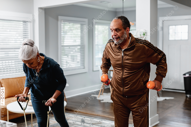 African American senior couple exercises together at home