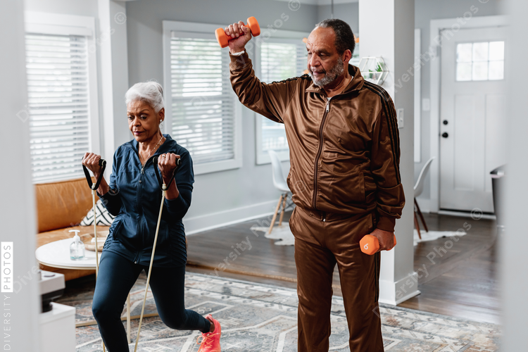 African American senior couple exercises together at home