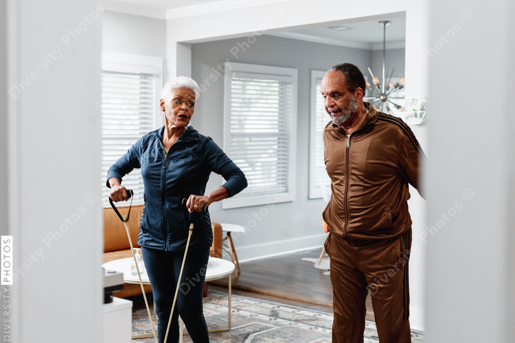 African American senior couple exercises together at home