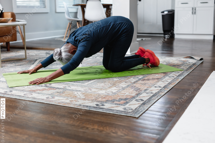 Senior woman doing child pose yoga fitness at home
