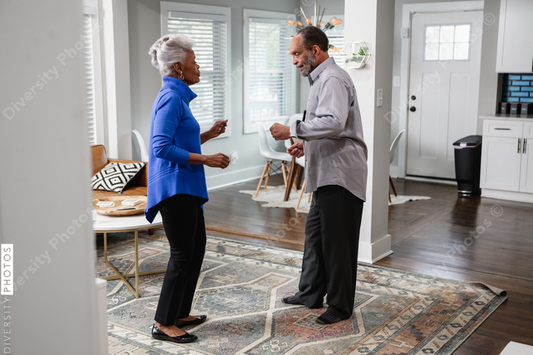 Black senior couple enjoys retirement at home dancing to music
