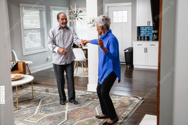 African American couple dances in living room, active lifestyle community