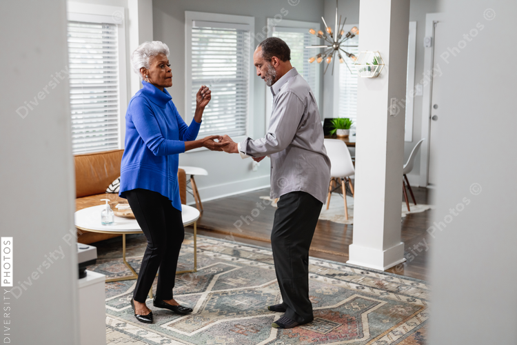 African American couple dances in living room, active lifestyle community