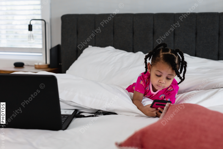 Young girl playing games on parent phone