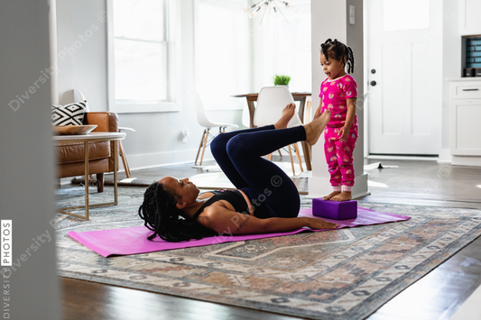 African American woman doing exercises at home with child
