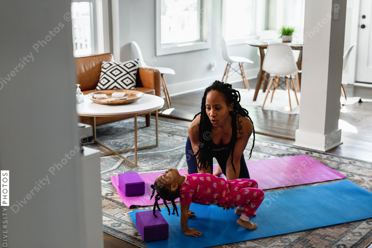 African American mother helping daughter exercise