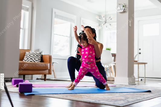 Black mother helps daughter exercise at home