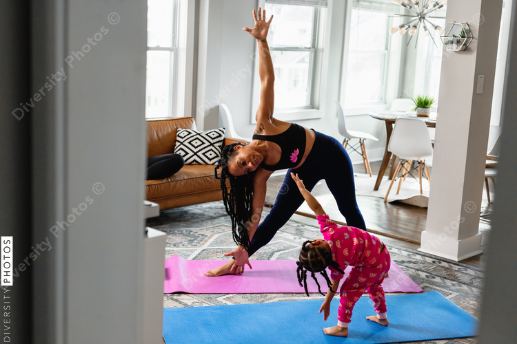 Mother and daughter doing yoga in living room