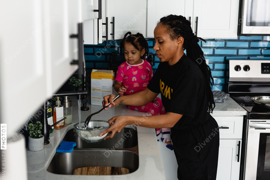 Black army mother cooks breakfast in kitchen with daughter