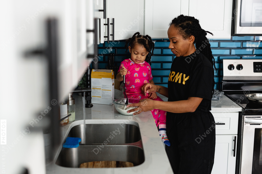 Black army mother cooks breakfast in kitchen with daughter