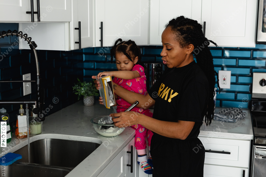 Black army mother cooks breakfast in kitchen with daughter