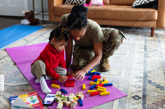 Black mother and daughter playing games in family room at home