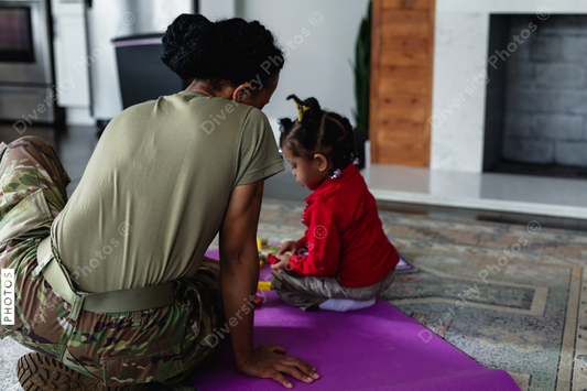 Black mother and daughter playing games in family room at home