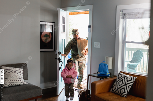Black soldier brings home groceries with daughter