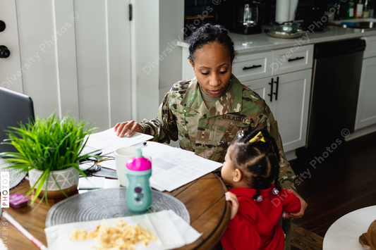 Black mother and daughter paying bills at home, soldier