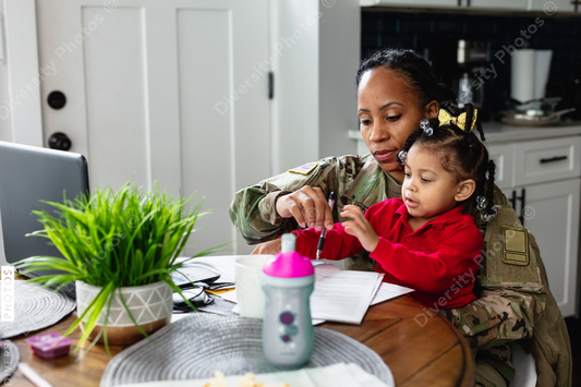Black mother and daughter paying bills at home, soldier