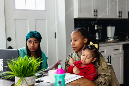 Black family paying bills at home, soldier