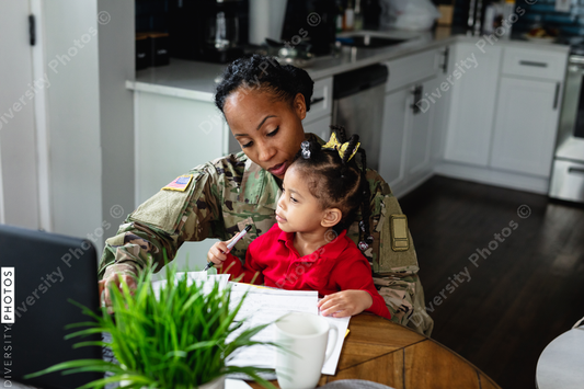 Black mother and daughter paying bills at home, soldier
