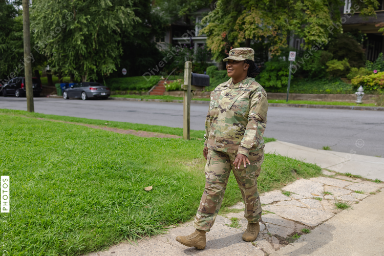 Black Military woman in camouflage uniform walking on front yard