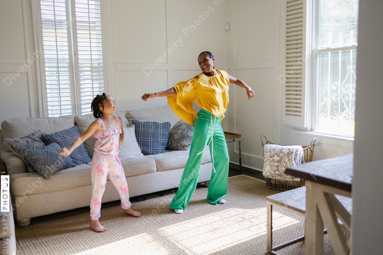 Mother and daughter learning to dance at home