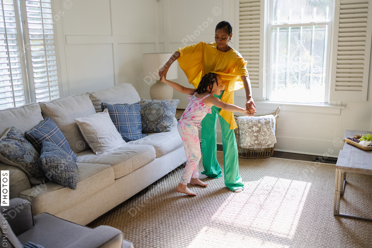 Mother and daughter learning to dance at home