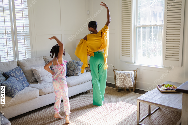 Mother and daughter learning to dance at home