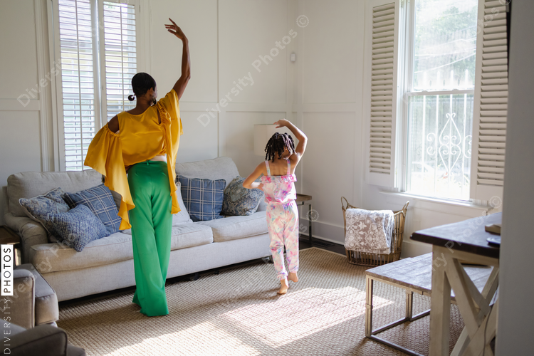 Mother and daughter learning to dance at home