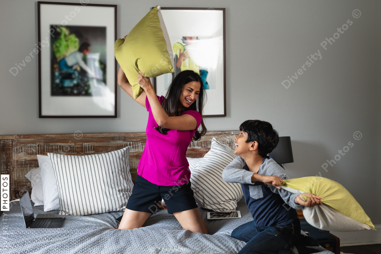 Indian mom and son playing around at home, pillow fight, fun moment