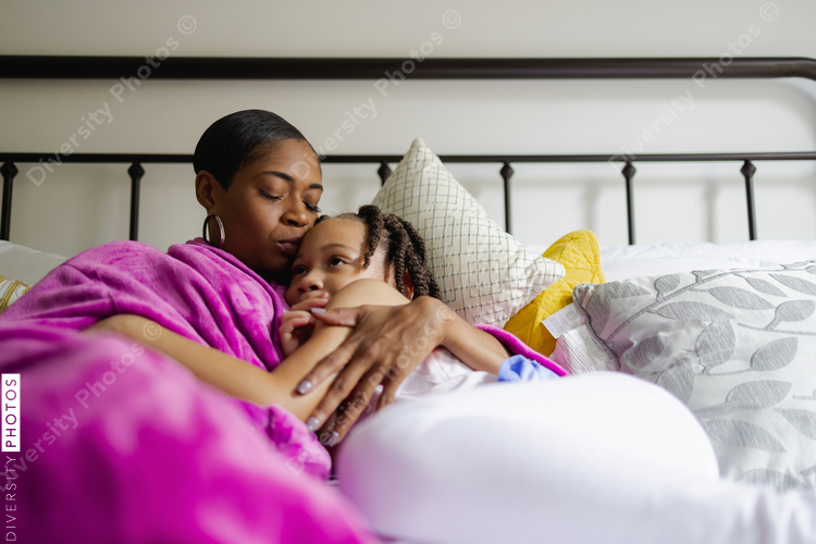 Mother and daughter hugging in bed