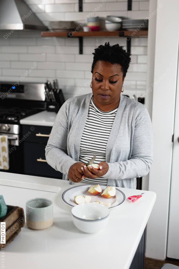 Black woman prepares a lite snack in the kitchen