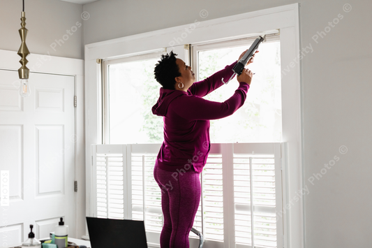 Black woman caulks window sill, energy efficiency, home improvement, DIY