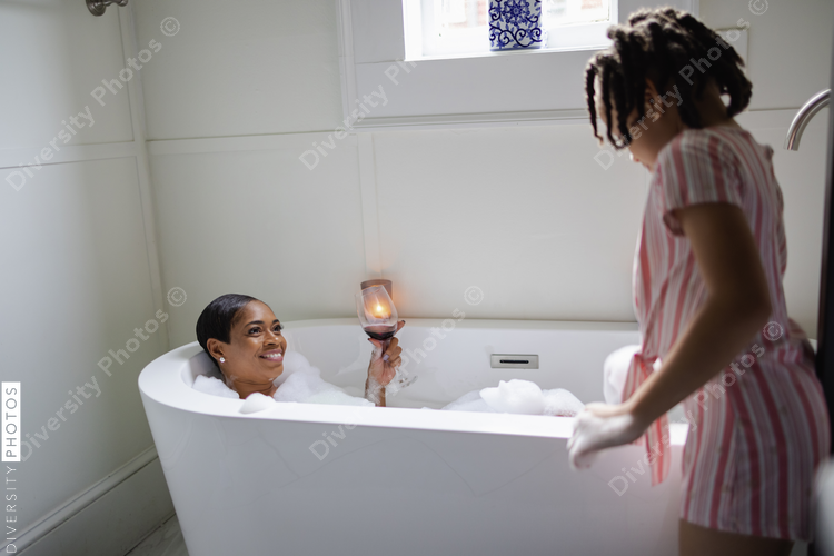 Daughter looking at mother taking bath