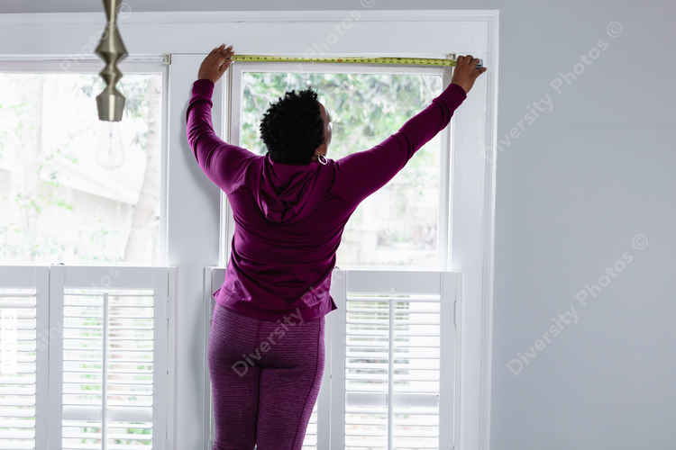 DIY, woman uses tape measure tool on window