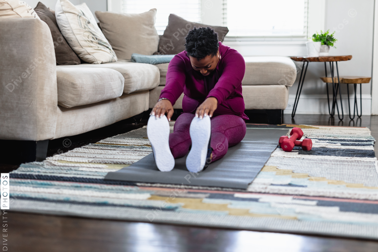 Black woman stretching at home in family room