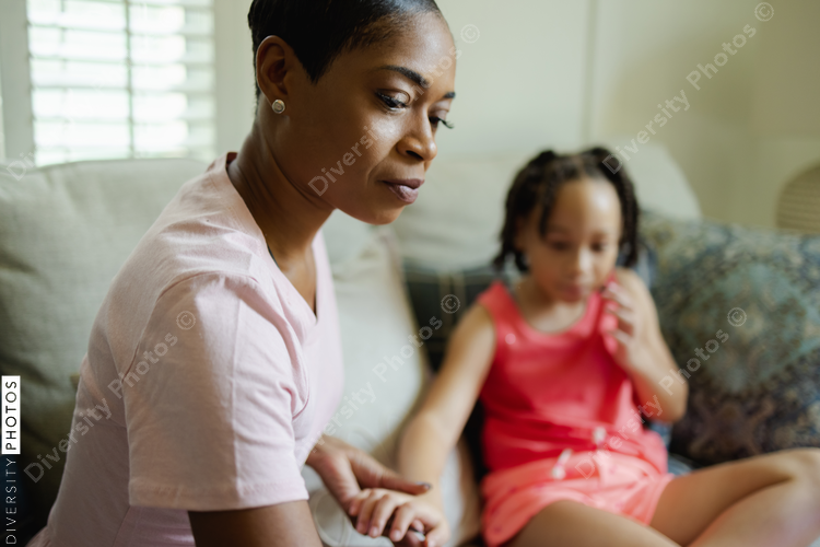 Mother and daughter sitting on sofa