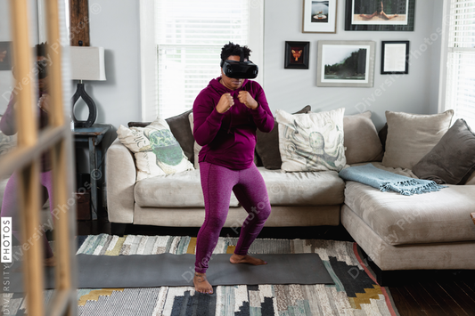 African American woman doing virtual reality VR boxing at home in living room