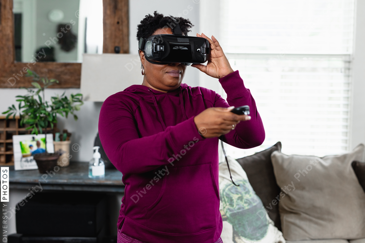 Black woman using virtual reality VR at home in living room