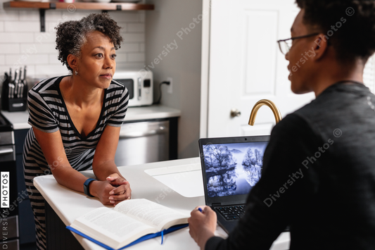 Black mother talking with son in kitchen at home