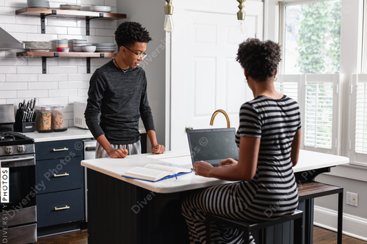 Black mother talking with son in kitchen at home
