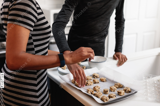 African American Mother and son preparing homemade baked cookies in kitchen