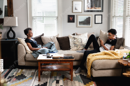 Black mother son having talk in family room, on couch, middle class home