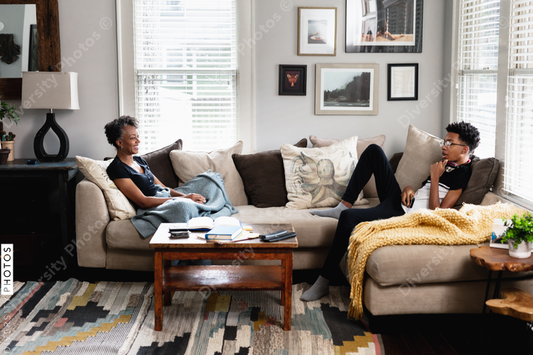Black mother son having talk in family room, on couch, middle class home