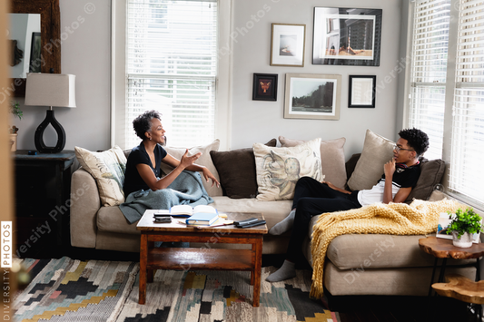 Black mother son having talk in family room, on couch, middle class home